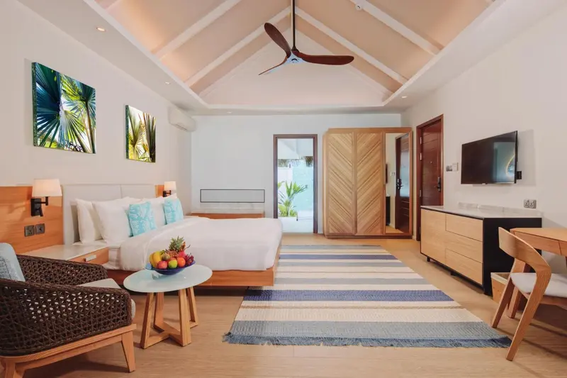 Une chambre lumineuse avec un grand lit et un espace détente.