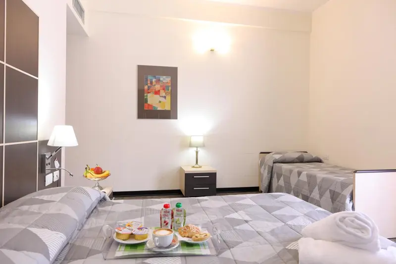 Une chambre d'hôtel avec deux lits et un plateau de petit-déjeuner.