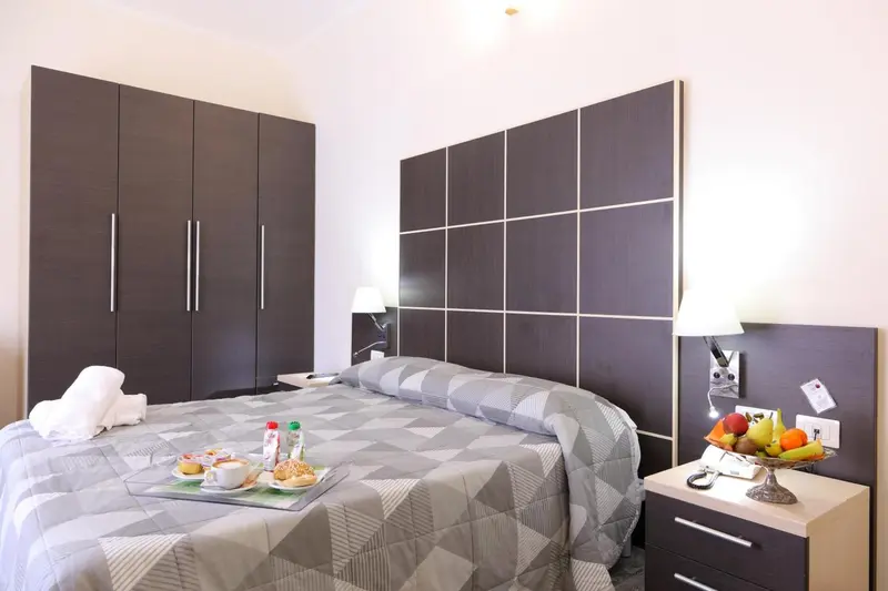 Une chambre avec un grand lit recouvert d'une couverture et de coussins.