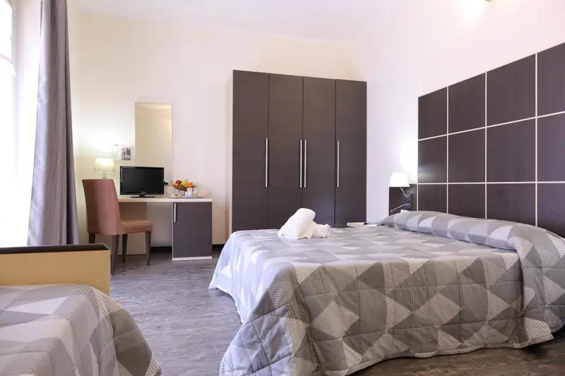 Une chambre lumineuse avec un grand lit et un bureau.