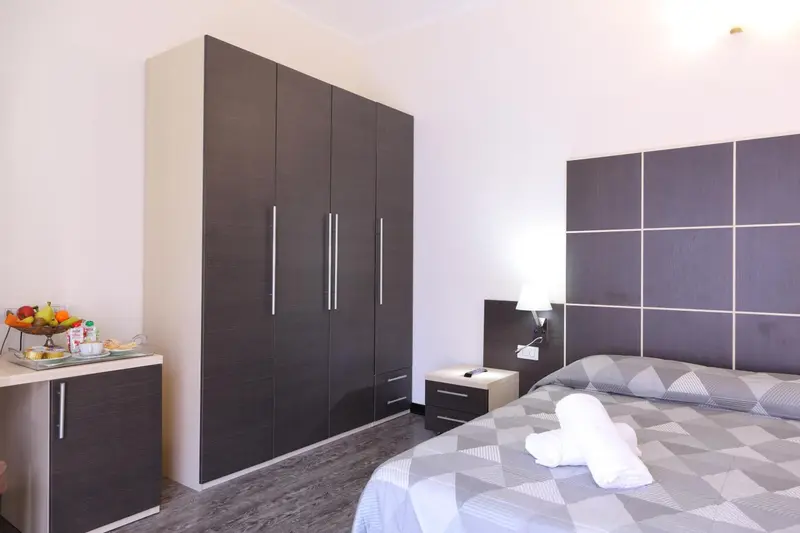 Une chambre moderne avec un grand lit et un placard intégré.