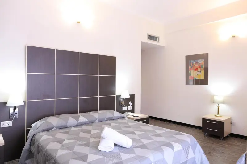 Une chambre lumineuse avec un grand lit et des tables de chevet.