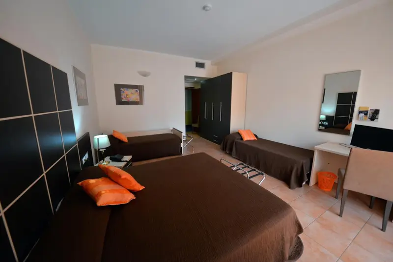 Une chambre avec deux lits simples et une commode.