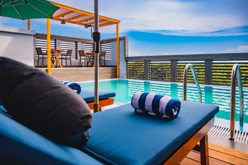 Transats bleus et rayés au bord d'une piscine sur terrasse.