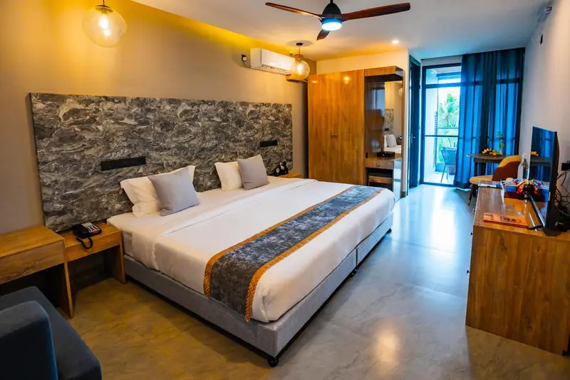 Une chambre lumineuse avec un grand lit et un accès à une terrasse.