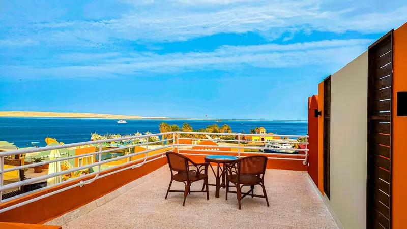 Terrasse avec mobilier de jardin et vue sur la mer.