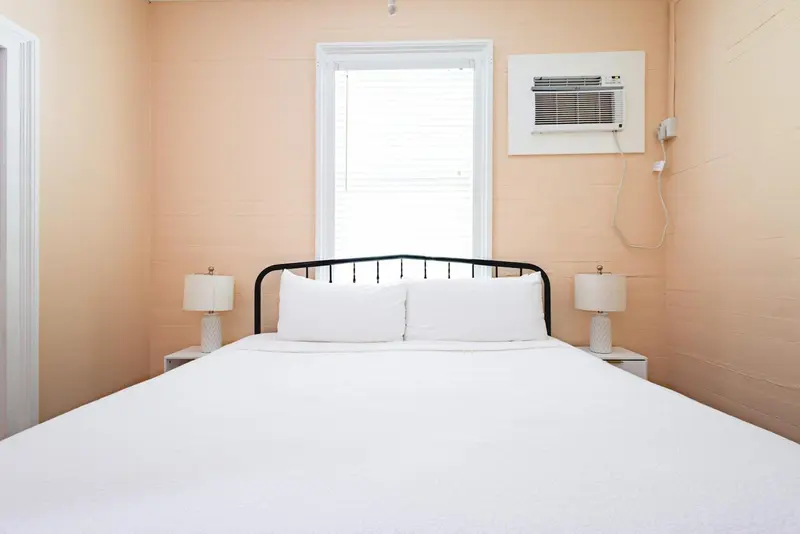 Une chambre lumineuse avec un lit double et des tables de chevet.