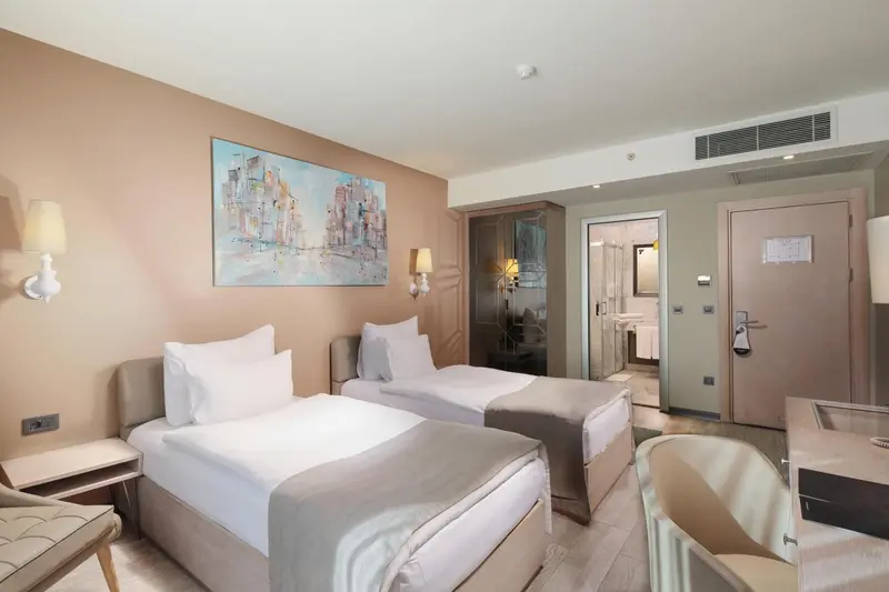 Chambre d'hôtel avec deux lits simples et une décoration murale.