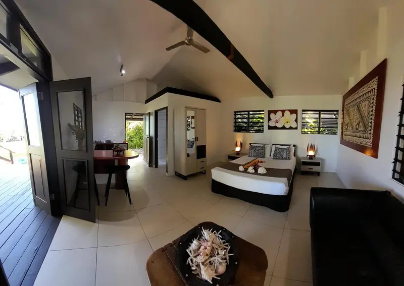 Espace de vie intérieur lumineux avec lit et coin repas.
