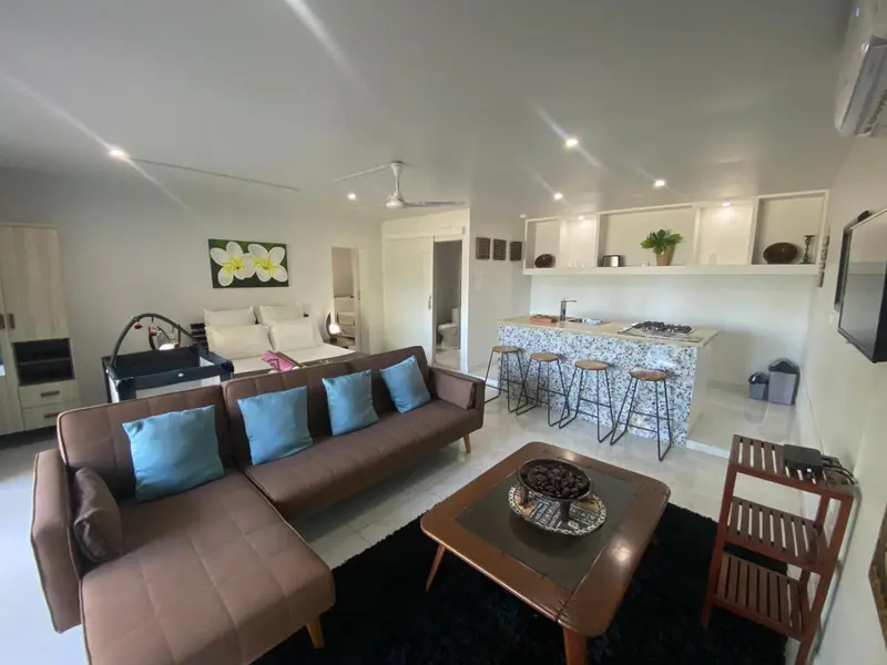 Espace de vie intérieur avec canapé, table basse et coin repas.