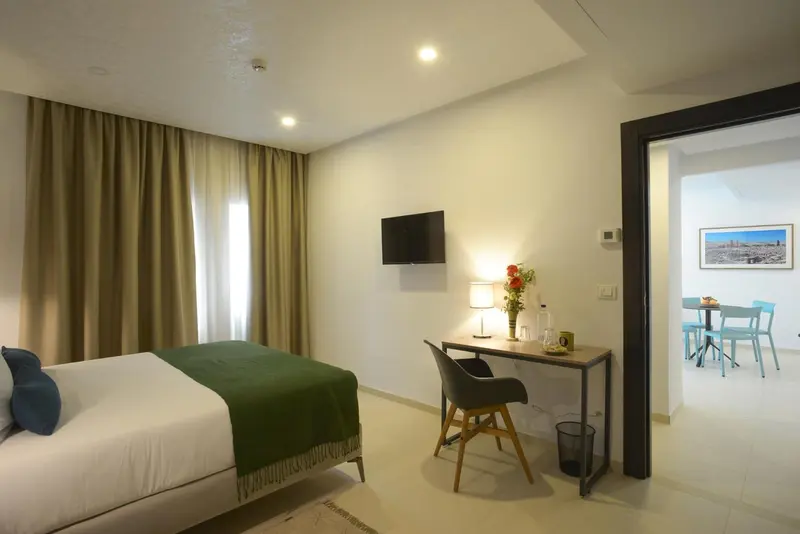 Une chambre lumineuse avec un lit et un espace bureau.