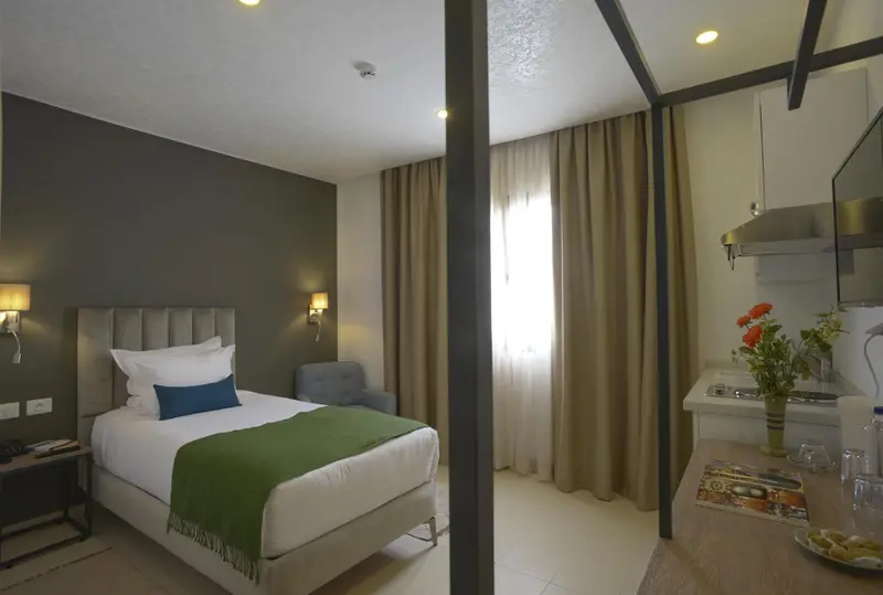 Une chambre avec un lit et une kitchenette.