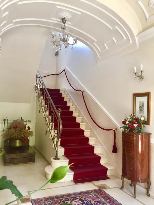 Un escalier en colimaçon rouge et blanc orne un hall d'entrée lumineux.
