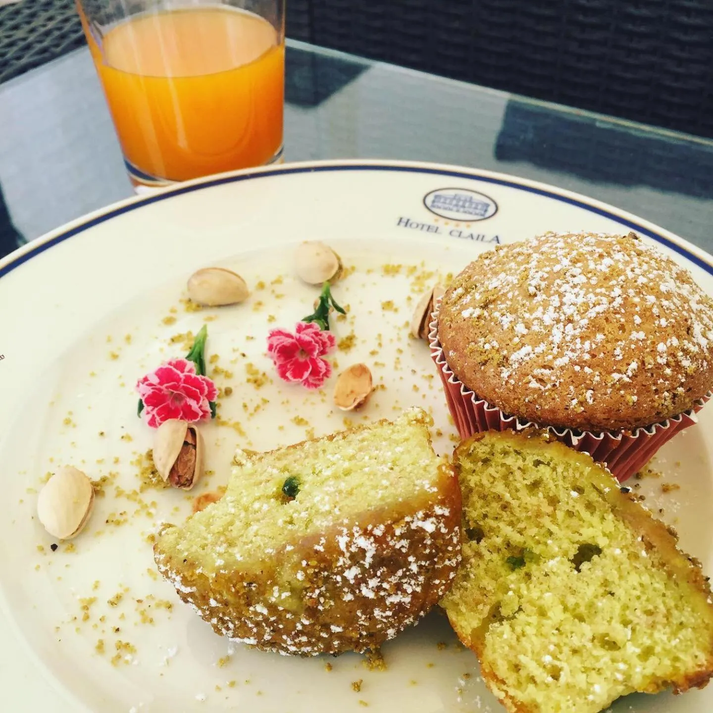 Un petit-déjeuner avec un muffin et un jus d'orange est présenté sur une table.