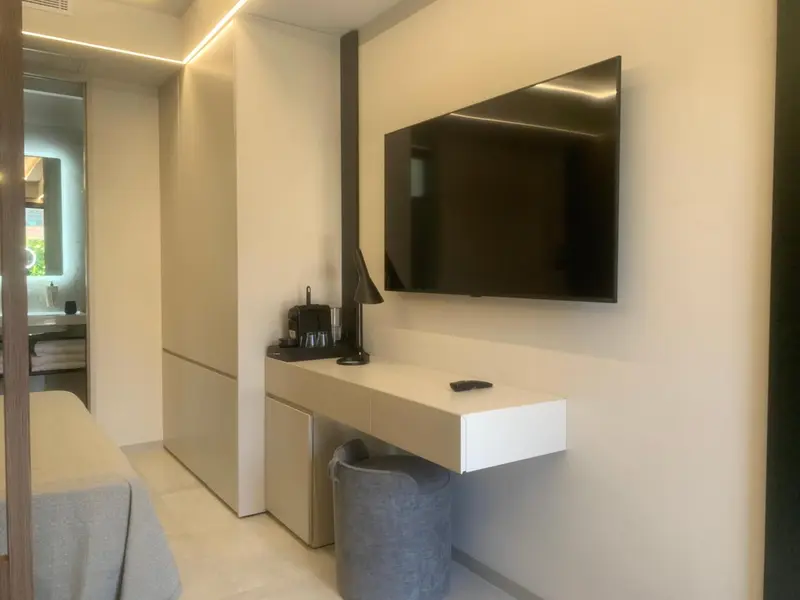 Une télévision murale domine un bureau minimaliste dans une chambre.