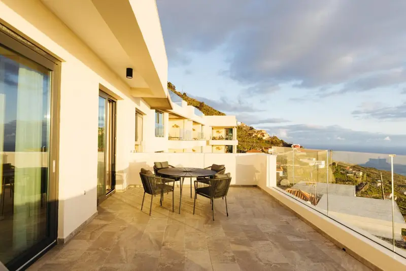 Terrasse avec mobilier de jardin et vue sur le paysage.