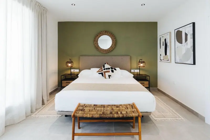 Une chambre lumineuse avec un grand lit et une décoration sobre.