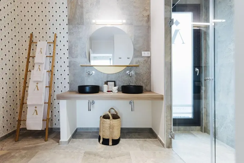 Une salle de bain moderne avec deux vasques et une douche vitrée.