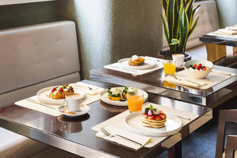 Des tables sont dressées avec des assiettes de nourriture et des boissons.