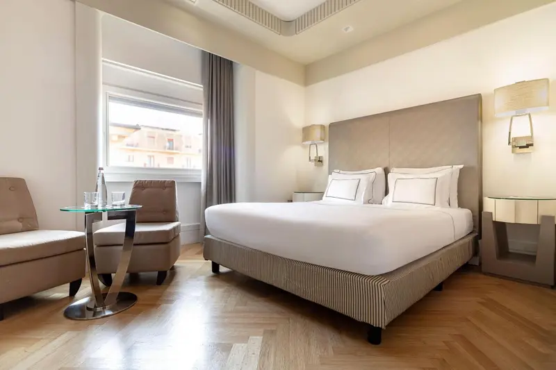 Une chambre lumineuse avec un grand lit et un coin salon.