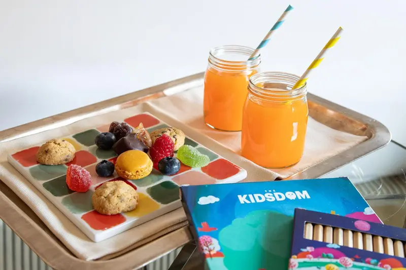 Assiette de fruits et de biscuits avec des boissons sur un plateau.
