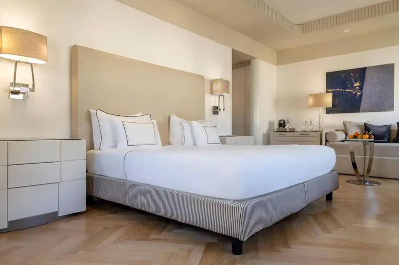 Une chambre lumineuse avec un grand lit et une décoration sobre.