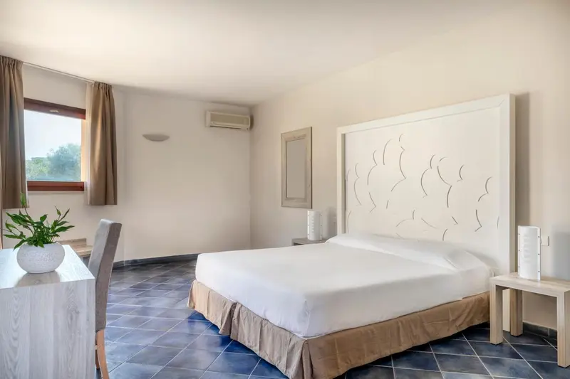 Une chambre lumineuse avec un grand lit et une décoration sobre.
