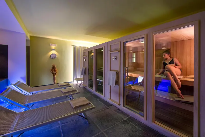 Espace de relaxation avec transats et saunas individuels.