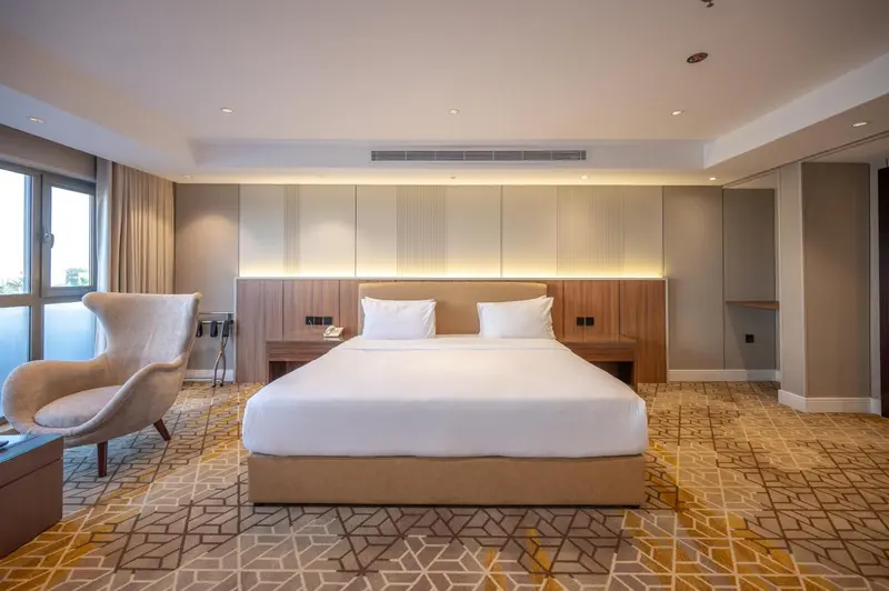 Une chambre d'hôtel moderne avec un grand lit et un fauteuil.