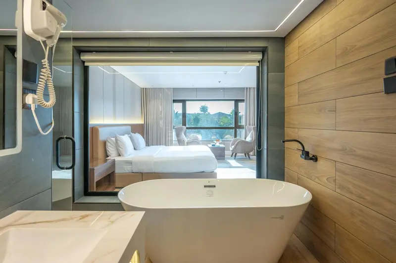 Une baignoire blanche se trouve dans une salle de bain moderne avec des murs carrelés.