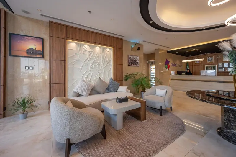 Un espace d'accueil lumineux avec des fauteuils et un canapé.
