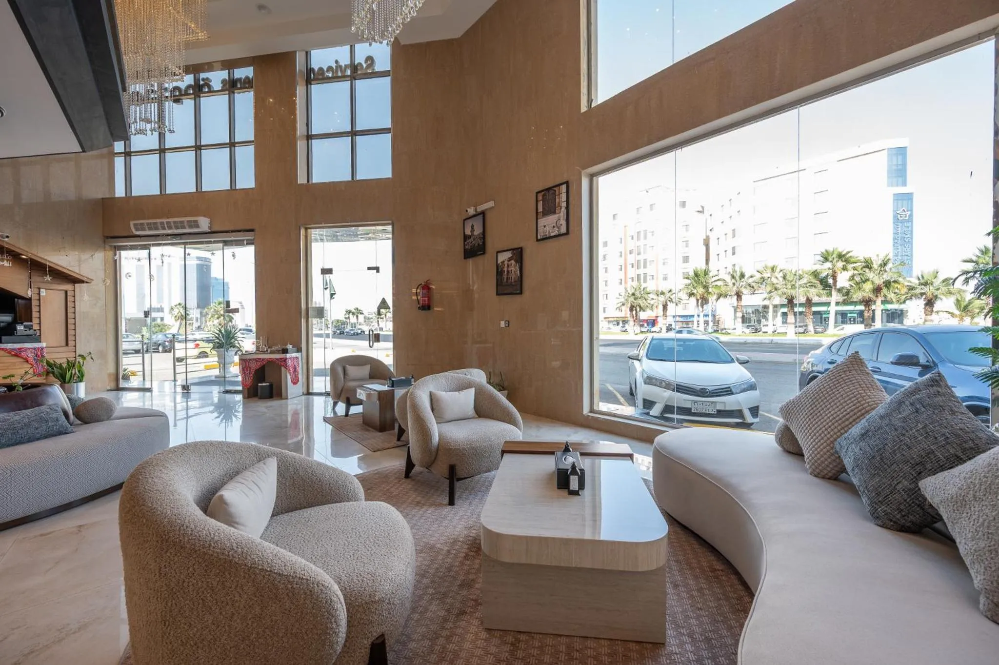 Espace de détente lumineux avec canapés et fauteuils confortables près de grandes fenêtres.