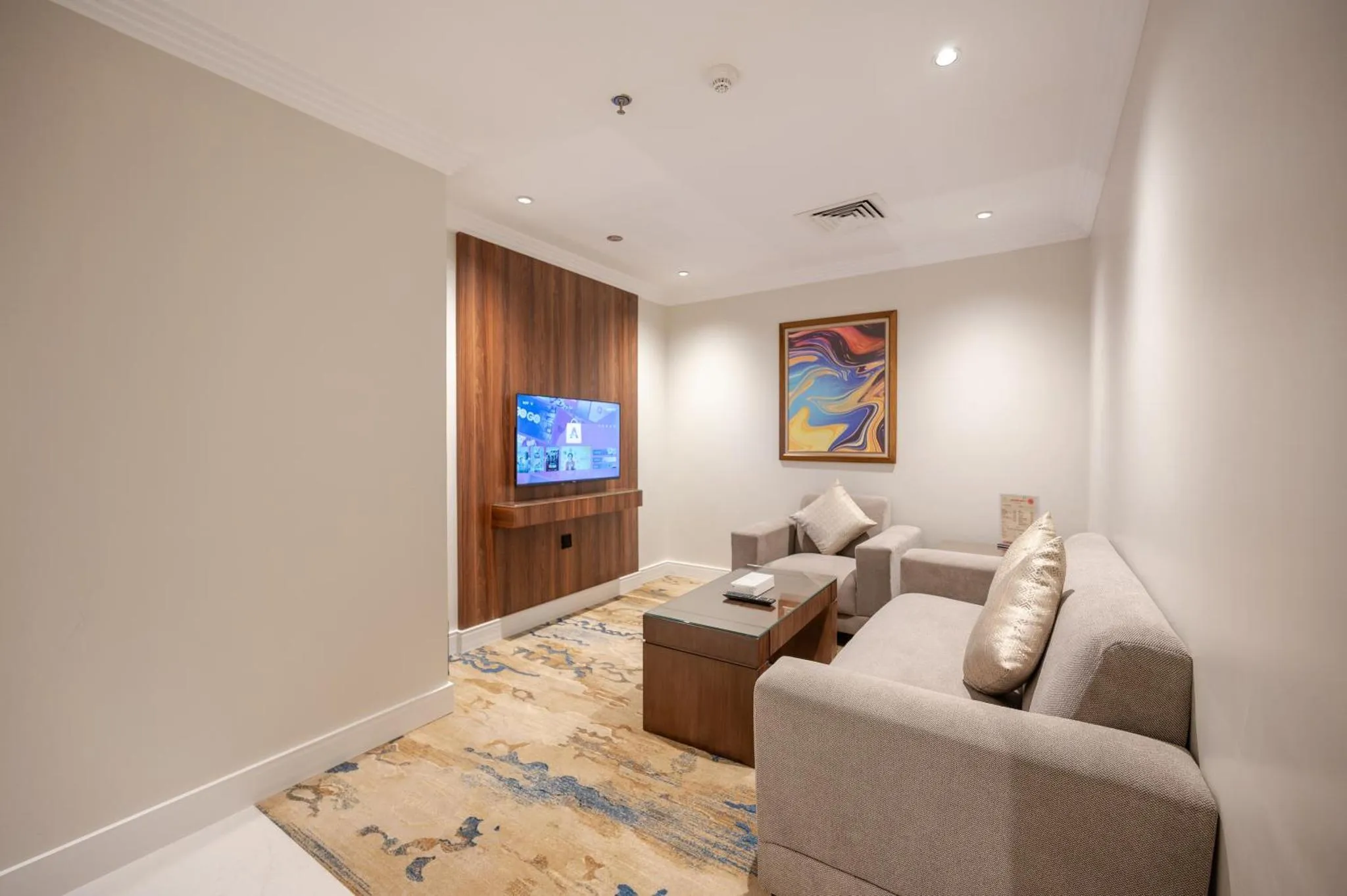 Espace de détente avec canapés et télévision murale.