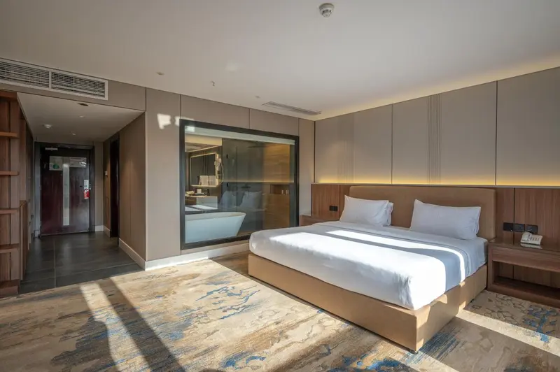 Une chambre lumineuse avec un grand lit et un espace détente.