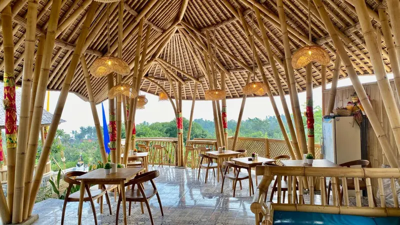 Une salle à manger en bambou s'ouvre sur un paysage verdoyant.