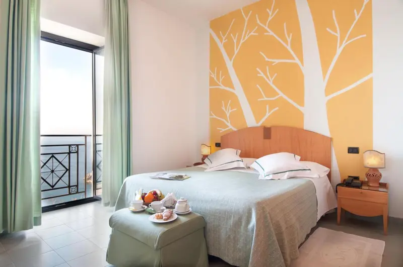 Une chambre lumineuse avec un lit double et un balcon.