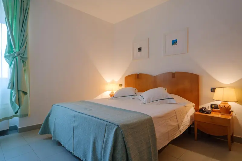 Une chambre lumineuse avec un grand lit recouvert d'une couverture.