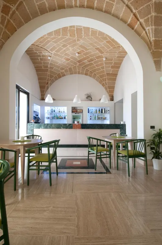 Une salle lumineuse avec un comptoir de bar et des tables à manger.