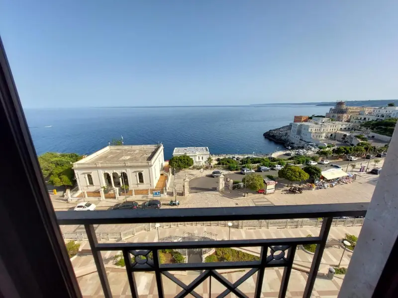Vue sur la mer et la ville depuis un balcon.