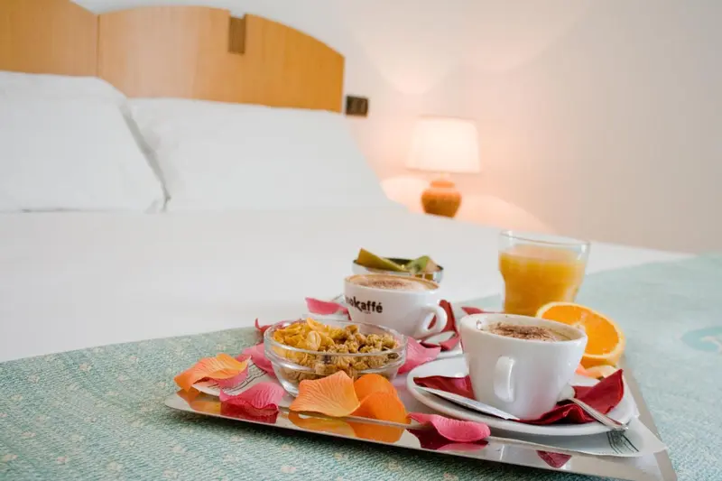 Petit déjeuner servi sur un plateau au bord d'un lit.