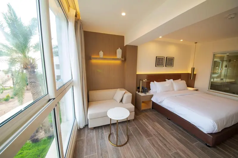 Chambre lumineuse avec canapé et lit double.