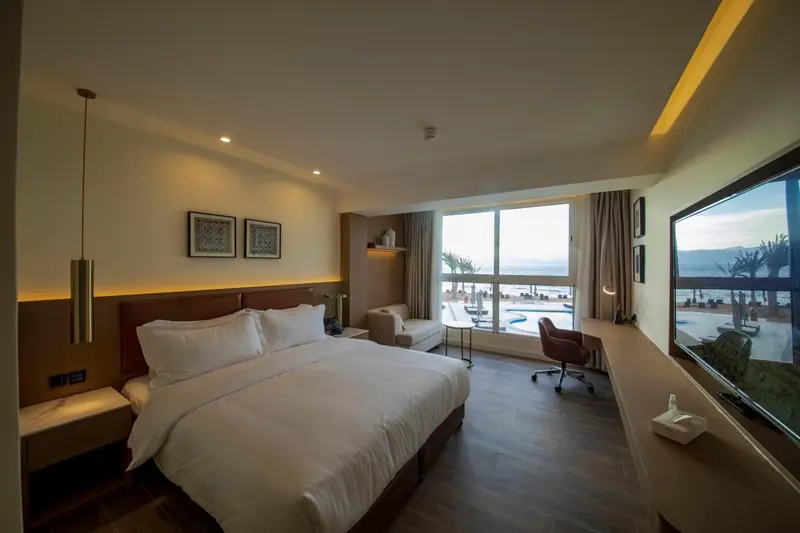 Une chambre lumineuse avec un grand lit et une vue sur la mer.