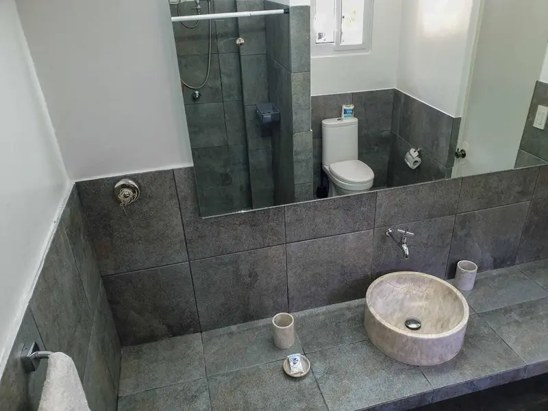 Une salle de bain moderne avec carrelage gris et vasque intégrée.
