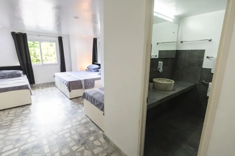 Une chambre lumineuse avec deux lits et une salle de bain moderne.