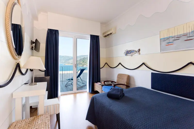 Chambre lumineuse avec vue sur la mer et balcon.
