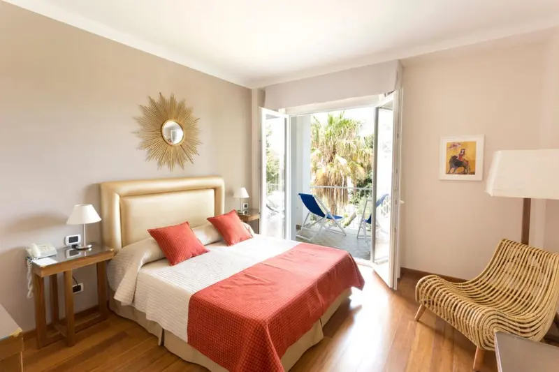Une chambre lumineuse avec un grand lit et un accès à un balcon.