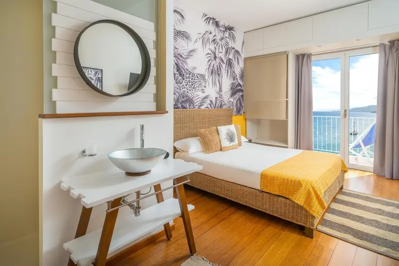 Une chambre lumineuse avec un lit et un lavabo.