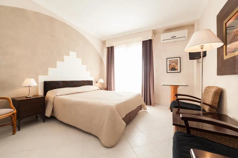 Une chambre lumineuse avec un grand lit et un coin lecture.
