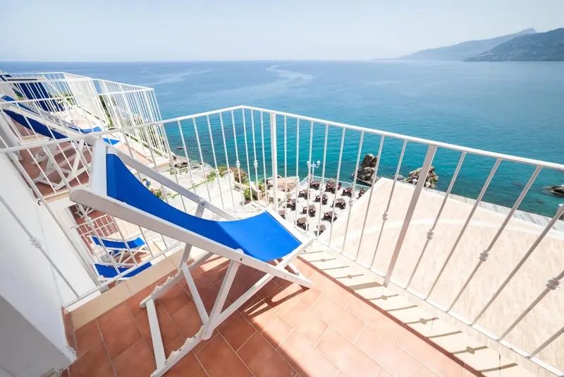 Terrasse avec transats et vue sur la mer.