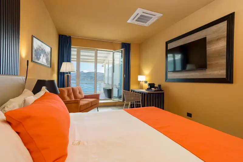 Chambre lumineuse avec un lit orange et un canapé.